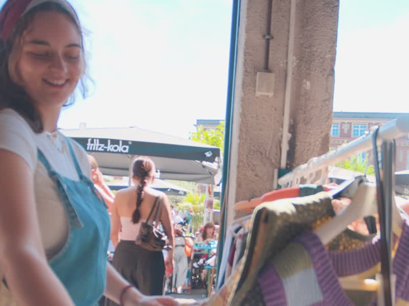 Besucherin stöbert durch Secondhand-Kleidung auf dem Kramkultur Flohmarkt